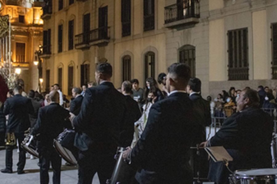 La banda tras un paso, de noche, con el uniforme actual